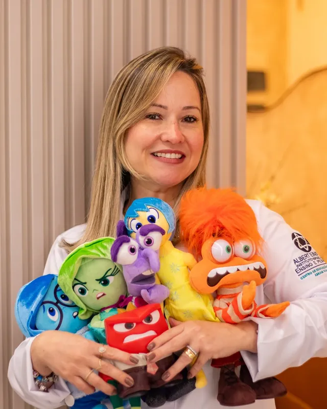 Raquel com bonecos de pelúcia das emoções